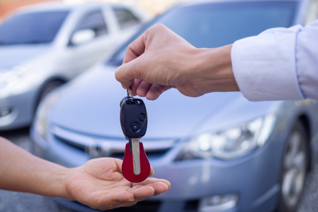 the car salesman and the key to the new owner.